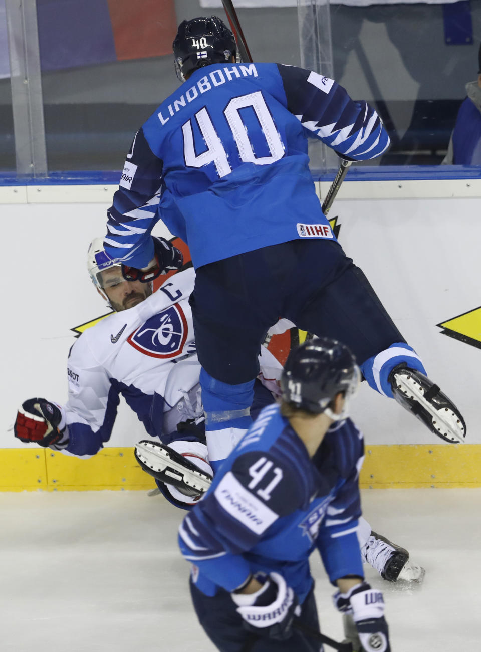 Finland's Joel Kiviranta, down, looks back as Finland's Petteri Lindbohm, right, checks Damien Fleury of France, left, during the Ice Hockey World Championships group A match between France and Finland at the Steel Arena in Kosice, Slovakia, Sunday, May 19, 2019. (AP Photo/Petr David Josek)