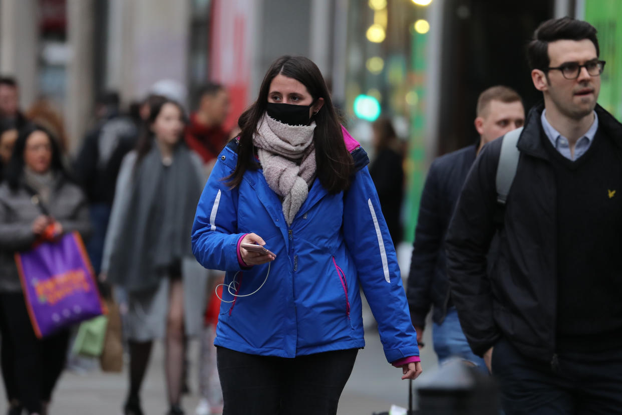 A woman wearing a face mask mask in Oxford Street in London, as Health Secretary Matt Hancock has said ministers are yet to make a decision on whether to ban gatherings of over 500 people in the rest of the UK, after Scotland said it would bring in restrictions from Monday.