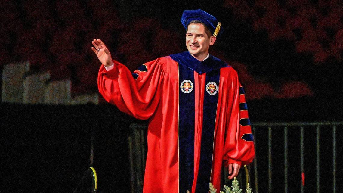 Dr. Saúl Jiménez-Sandoval waves while walking on stage during the processional for his investiture ceremony to formally become Fresno State’s ninth president at the Save Mart Center on Friday, Sept. 9, 2022.