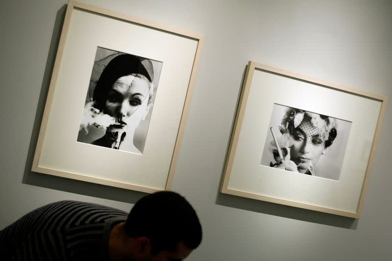 FILE PHOTO: Man passes by photographs by Klein during media preview of photo exhibit "Mujeres en Plural" in Madrid