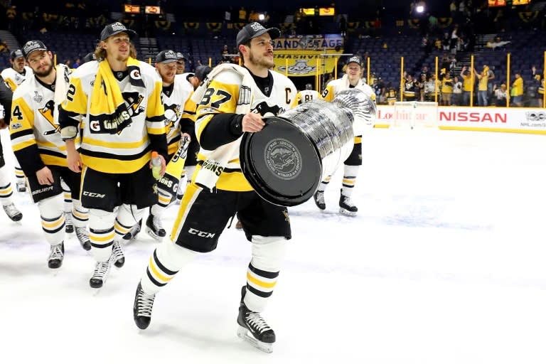 Sidney Crosby and his Pittsburgh Penguins teammates celebrate with the trophy after defeating the Nashville Predators 2-0 to win the 2017 NHL Stanley Cup Final, at the Bridgestone Arena in Nashville, Tennessee, on June 11, 2017