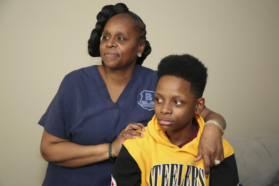Tirzah Patterson and her son Jaques "Jake" Patterson pose for a picture at their home, Tuesday, May. 9, 2023, in Buffalo, N.Y. Jake, 13, is the youngest child of beloved church deacon Heyward Patterson, who was gunned down at a supermarket a year ago, Sunday. Tirzah will dedicate this Mother’s Day to the hardest part of a mother’s job, trying to help her child make sense of tragedy. (AP Photo/Jeffrey T. Barnes)