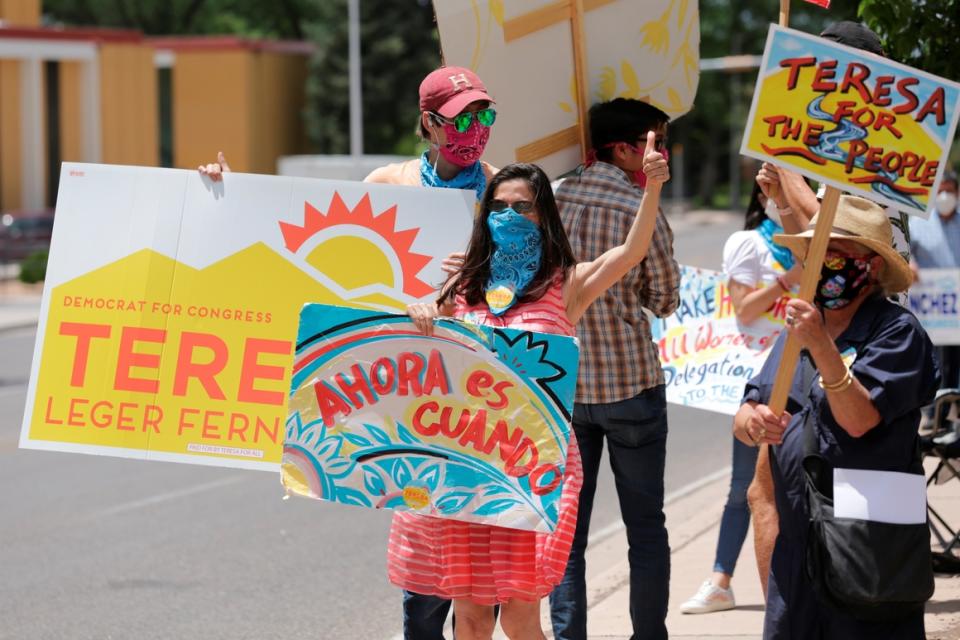 Democratic congressional candidate Teresa Leger Fernandez flashes a thumbs-up to drivers at a polling station in Santa Fe, N.M.  She won her primary.