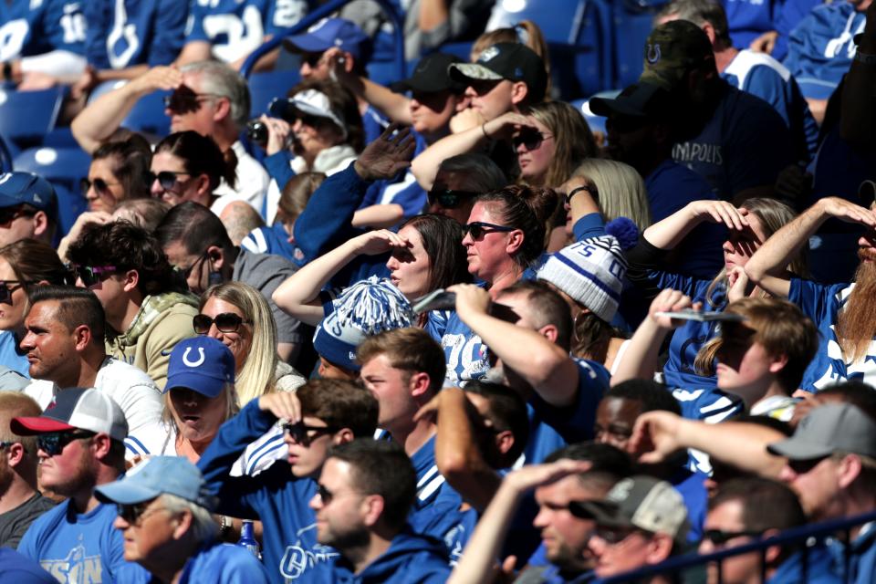 Fans shade their eyes as they watch the Indianapolis Colts move down the field Sunday, Oct. 17, 2021, during a game against the Houston Texans at Lucas Oil Stadium in Indianapolis.