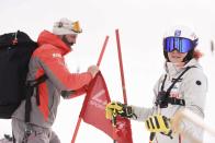 Visar Kryeziu, a photographer with The Associated Press and father of Kiana Kryeziu, right, fixes flags as he sets a ski course during training at the Arxhena Ski center in Dragas, Kosovo on Saturday, Jan. 22, 2022. The 17-year-old Kryeziu is the first female athlete from Kosovo at the Olympic Winter Games after she met the required standards, with the last races held in Italy. (AP Photo)