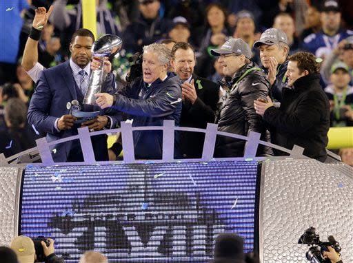 Seattle Seahawks head coach Pete Carroll holds the Vince Lombardi Trophy as he celebrates with team president Peter McLoughlin, center rear, owner Paul Allen, third from right, and general manager John Schneider, right, after the NFL Super Bowl XLVIII football game against the Denver Broncos Sunday, Feb. 2, 2014, in East Rutherford, N.J. The Seahawks won 43-8. (AP Photo/Chris O'Meara)