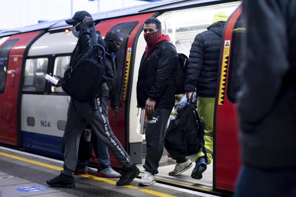 Commuters alight from a tube train wearing face masks at Canning Town station in London after a rail fare increase came into effect on Monday March 1, 2021. Ticket prices have increased Monday, as people are still encouraged to work from home if possible, because of the coronavirus pandemic. (Aaron Chown/PA via AP)