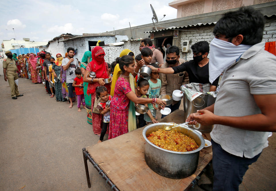 Slum dwellers receive free food during a 21-day nationwide lockdown to limit the spreading of the coronavirus disease (COVID-19), in Ahmedabad, India, March 27, 2020. REUTERS/Amit Dave