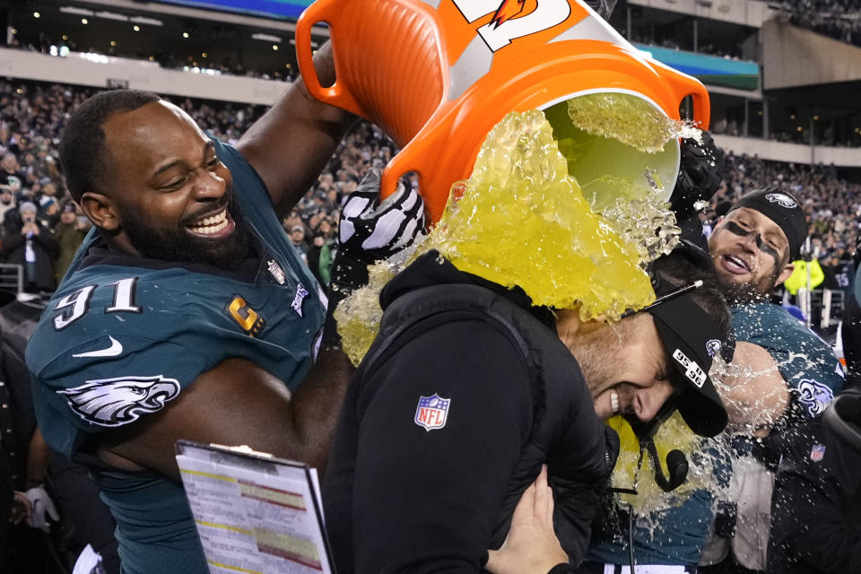 El entrenador de los Eagles de Filadelfia, Nick Sirianni (centro), es empapado por el defensive tackle Fletcher Cox, durante la segunda parte del juego por el campeonato de la Conferencia Nacional de la NFL contra los 49ers de San Francisco, el domingo 29 de enero de 2023, en Filadelfia. (AP Foto/Matt Slocum)