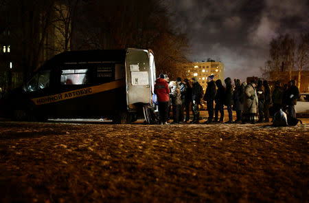 People queue near a van of 'Nochlezhka' charity organization as volunteers distribute meals for the homeless in St. Petersburg, Russia December 5, 2018. REUTERS/Anton Vaganov