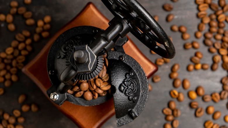 bean-filled manual coffee grinder