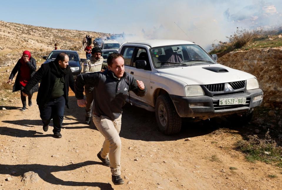 <div class="inline-image__caption"><p>Palestinians run for cover from tear gas during a protest against settlements in Masafer Yatta near Hebron, in the Israeli-occupied West Bank, January 20,2023.</p></div> <div class="inline-image__credit">Mussa Issa Qawasma via Reuters</div>