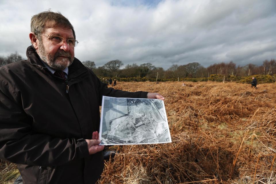 Councilor Graham Burgess of the local Hampsire council, holds a 1951 aerial photograph of the site, as he poses for the photographers at the site of WW1 practise trenches in Gosport, southern England, Thursday, March 6, 2014. This overgrown and oddly corrugated patch of heathland on England’s south coast was once a practice battlefield, complete with trenches, weapons and barbed wire. Thousands of troops trained here to take on the Germany army. After the 1918 victory _ which cost 1 million Britons their lives _ the site was forgotten, until it was recently rediscovered by a local official with an interest in military history. Now the trenches are being used to reveal how the Great War transformed Britain _ physically as well as socially. As living memories of the conflict fade, historians hope these physical traces can help preserve the story of the war for future generations. (AP Photo/Lefteris Pitarakis)