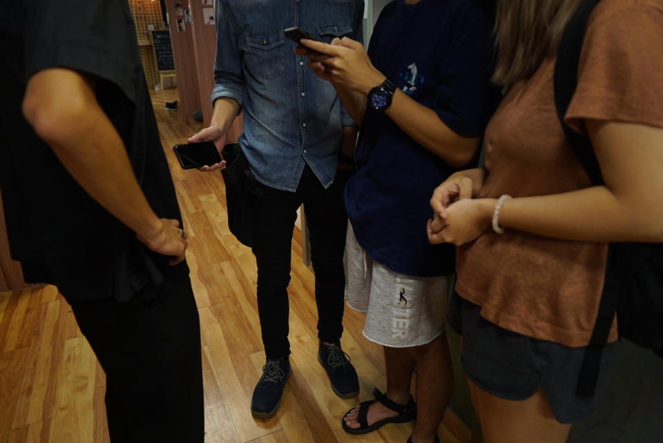 In this photo taken July 3, 2019, from left to right: John, Nick, Colin, and Daisy Chan, protesters who did not want their faces shown speak to a journalist about their taking part in recent pro-Democracy protests in Hong Kong. (AP Photo/Dake Kang)