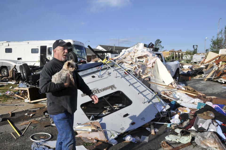 Damon Braley carries his mother's dog Sammy, which he rescued from under the wreckage of his parents' RV, at the Roadrunner RV Park in Oklahoma City, Oklahoma May 7, 2015. About a dozen people were injured by a series of tornadoes that touched down southwest of Oklahoma City, part of a storm system that flattened structures and caused severe flooding in several Great Plain states, officials said on Thursday. REUTERS/Nick Oxford