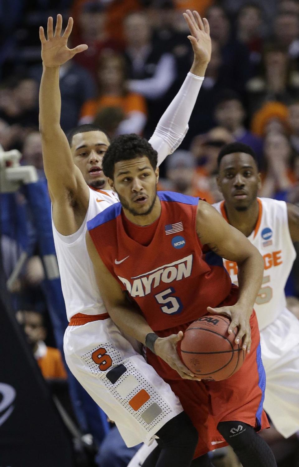 Dayton's Devin Oliver (5) passes away from Syracuse's Tyler Ennis during the first half of a third-round game in the NCAA men's college basketball tournament in Buffalo, N.Y., Saturday, March 22, 2014. (AP Photo/Frank Franklin II)