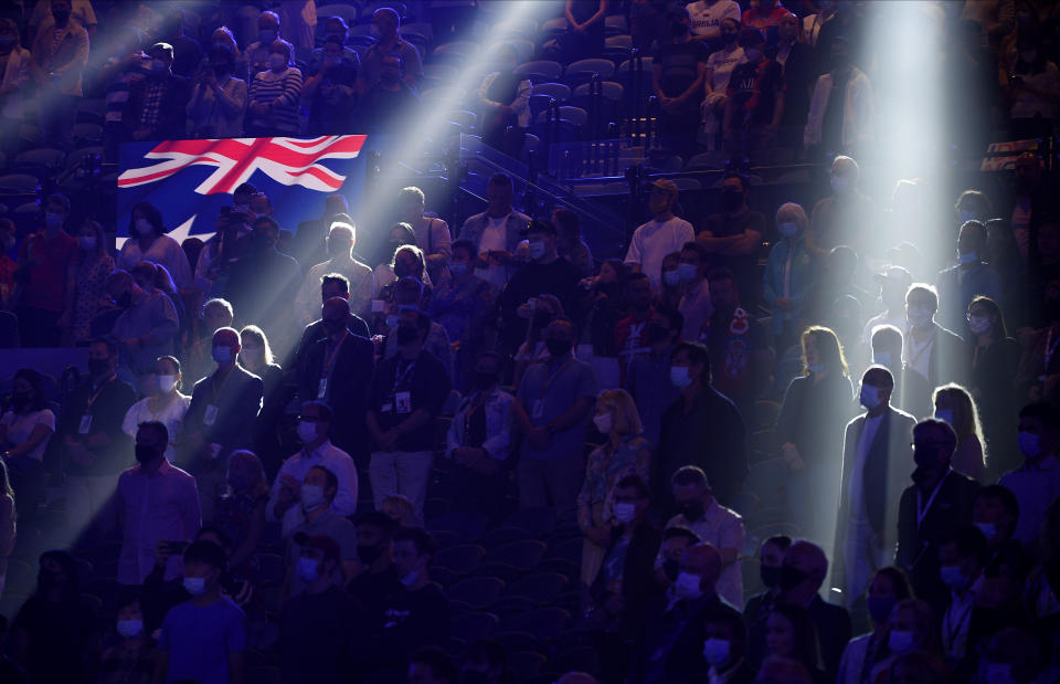 Spectators stand for the Australian national anthem ahead of the men's singles final Serbia's Novak Djokovic and Russia's Daniil Medvedev at the Australian Open tennis championship in Melbourne, Australia, Sunday, Feb. 21, 2021.(AP Photo/Andy Brownbill)