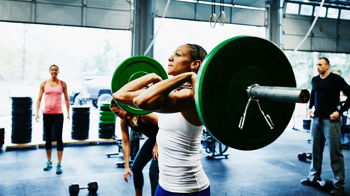 a person in a crossfit gym doing a barbell exercise