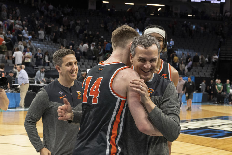 Princeton head coach Mitch Henderson embraces guard Matt Allocco (14) after their first-round college basketball game victory over Arizona in the NCAA Tournament in Sacramento, Calif., Thursday, March 16, 2023. Princeton won 59-55. (AP Photo/José Luis Villegas)