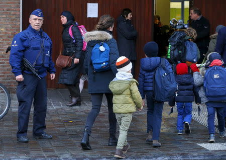 A Belgian police officer stands guard outside a school in central Brussels November 25, 2015. REUTERS/Yves Herman