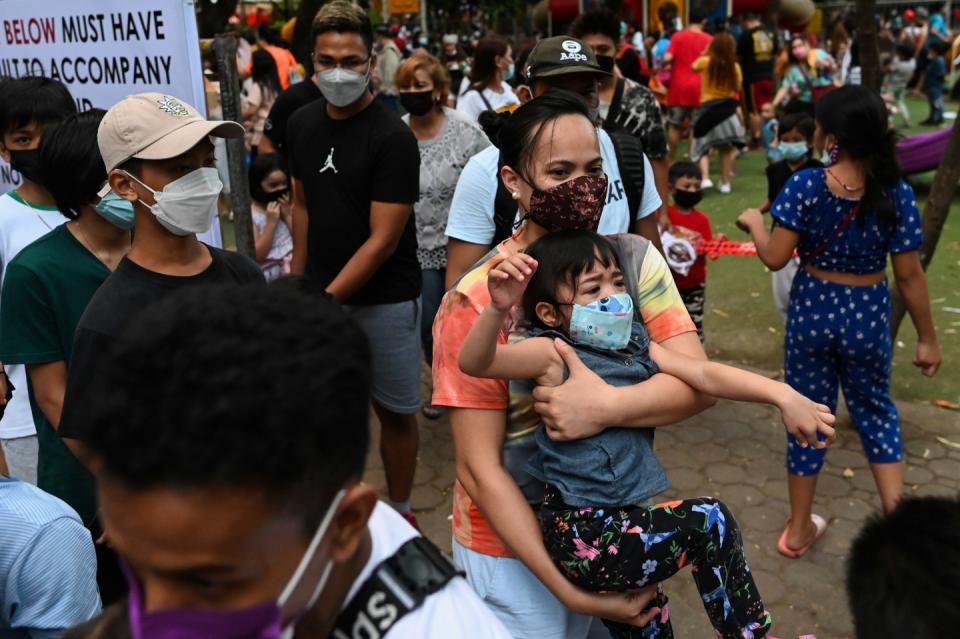 Parents and children prepare to leave a public park during its closing time, as the country's capital region loosens coronavirus disease (COVID-19) restrictions, in Quezon City, Metro Manila, Philippines, November 2, 2021. Picture taken November 2, 2021. REUTERS/Lisa Marie David