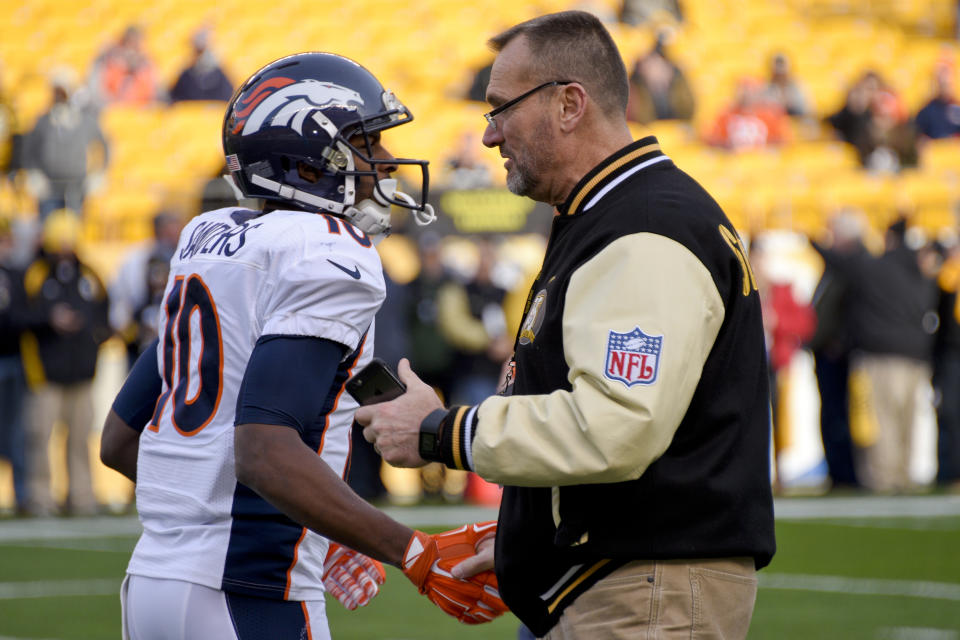 FILE - In this Dec. 20, 2015, file photo, Denver Broncos wide receiver Emmanuel Sanders (10) talks with former Pittsburgh Steelers lineman Tunch Ilkin before an NFL football game in Pittsburgh. Ilkin, a Turkis-born two-time Pro Bowl offensive lineman with the Pittsburgh Steelers in the 1980s who went on to become a beloved member of the organization's broadcast team, died on Saturday morning, Sept. 4, 2021, the team said. He was 63. Ilkin, who revealed last fall he was fighting amyotrophic lateral sclerosis (also known as Lou Gehrig's Disease), had been hospitalized recently with pneumonia. (AP Photo/Don Wright, File)