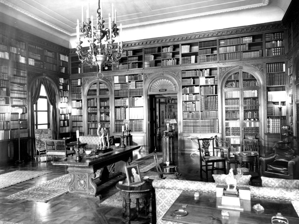 Books line the shelves of the Garrett family’s library in Baltimore with a candelabra chandelier in 1923.