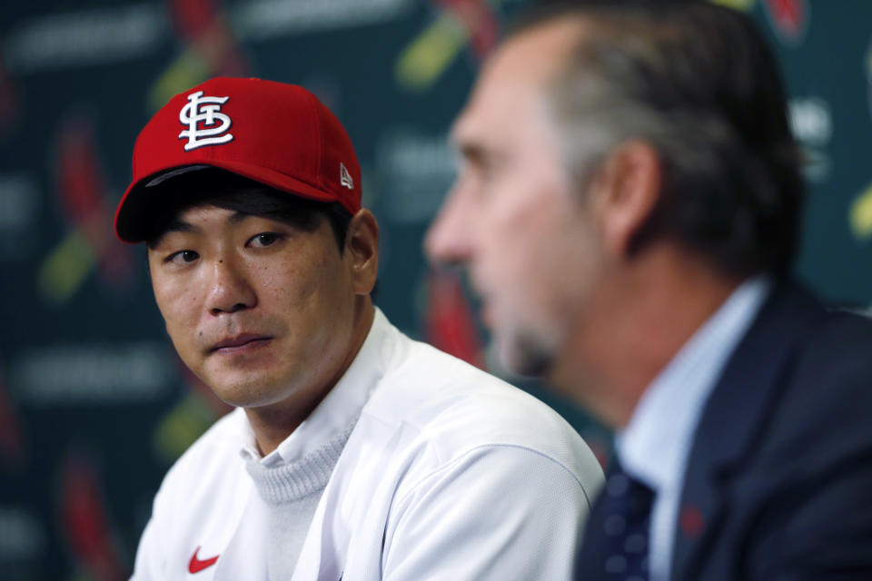 St. Louis Cardinals pitcher Kwang-Hyun Kim, left, listens as Cardinals president of baseball operations John Mozeliak answers a question during a news conference announcing his signing to the baseball team Tuesday, Dec. 17, 2019, in St. Louis. The Cardinals have signed the Korean left-hander to a two-year contract. (AP Photo/Jeff Roberson)