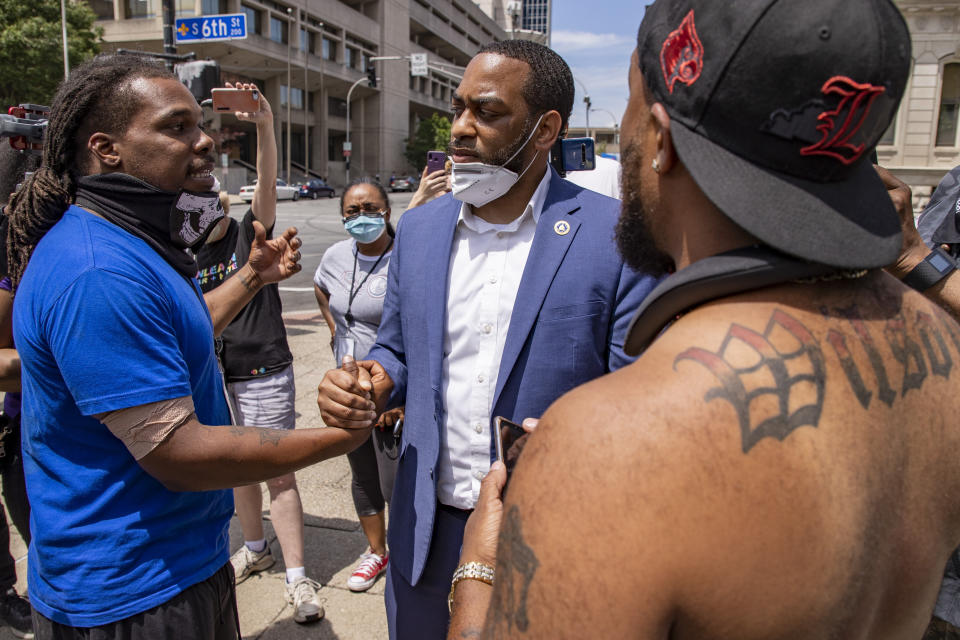 HOLD FOR STORY- In this June 17, 2020 photo U.S. Senate candidate Charles Booker shakes hands with protestors in Louisville, KY. Booker is running against Amy Grath for the senate democratic nomination. (Alton Strupp/Louisville Courier Journal via AP)