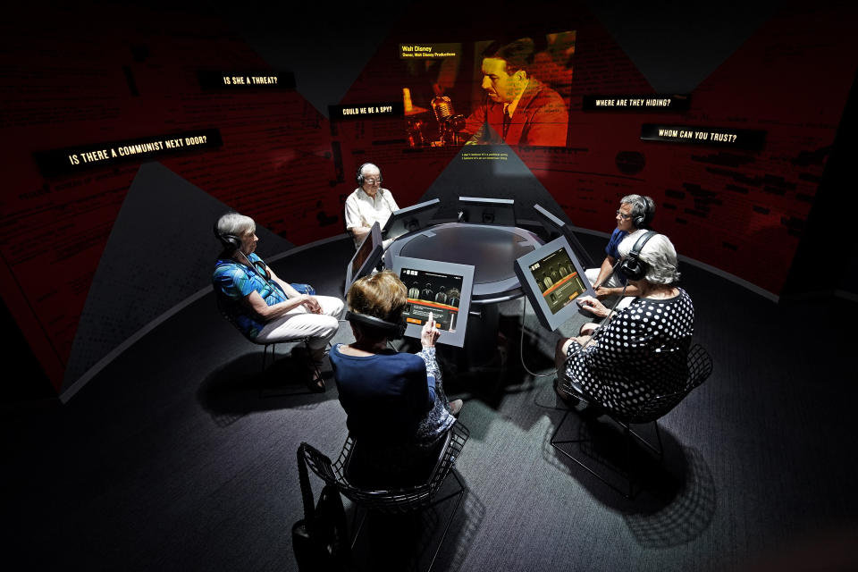 People take part in an interactive exhibit about the red scare during a tour of the Harry S. Truman Presidential Library and Museum Wednesday, June 9, 2021, in Independence, Mo. The facility will reopen July 2 after a nearly $30 million renovation project. (AP Photo/Charlie Riedel)