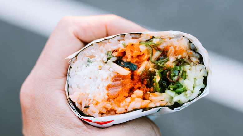 hand holding sushi burrito