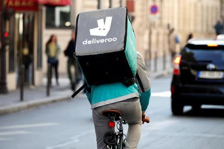 A cyclist rides a bicyle as he delivers food for Deliveroo, an example of the emergence of what is known as the 'gig economy', in Paris, France, April 7, 2017. Picture taken April 7, 2017. REUTERS/Charles Platiau