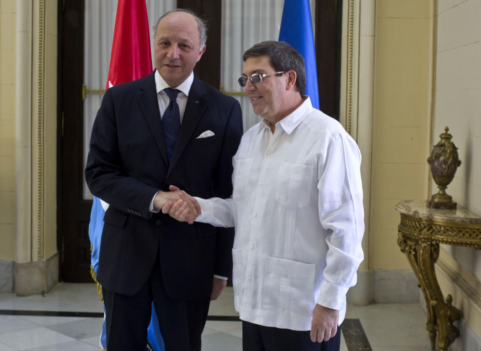 Cuba's Foreign Minister Bruno Rodriguez, right, and France's Foreign Minister Laurent Fabius shake hands toward photographers prior to their meeting at the Foreign Ministry in Havana, Cuba, Saturday, April 12, 2014. France's foreign minister is visiting Cuba for the first time in 30 years at a time when the communist-led Caribbean nation is seeking to draw more foreign investment and improve ties with the European Union. (AP Photo/Ramon Espinosa)