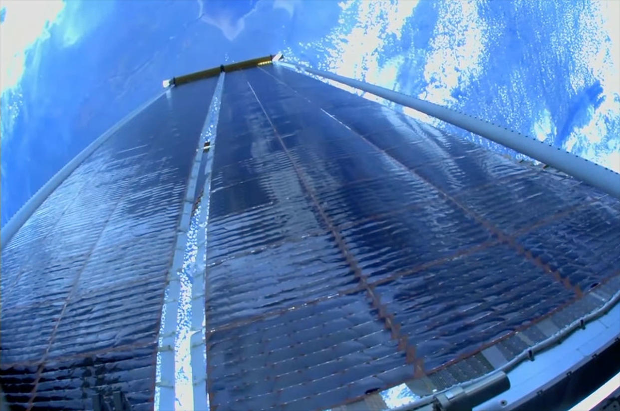  Photo from a spacewalking astronaut of newly installed solar array on the international space station, with earth in the background. 