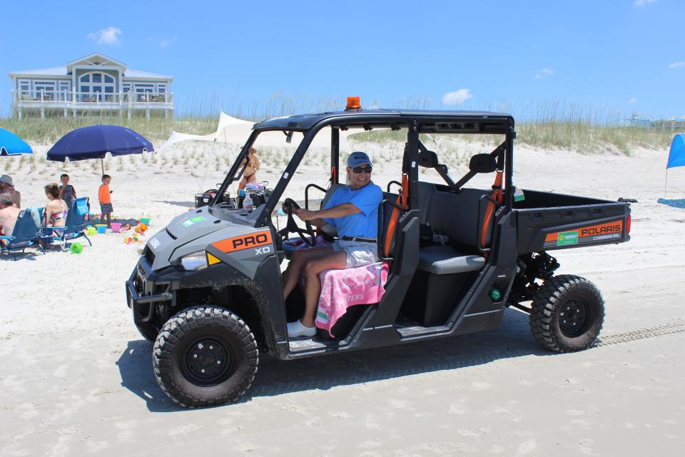 Cynthia Grant, an employee with Oak Island's new Beach Services Unit, patrols the beach strand on a busy Saturday morning.