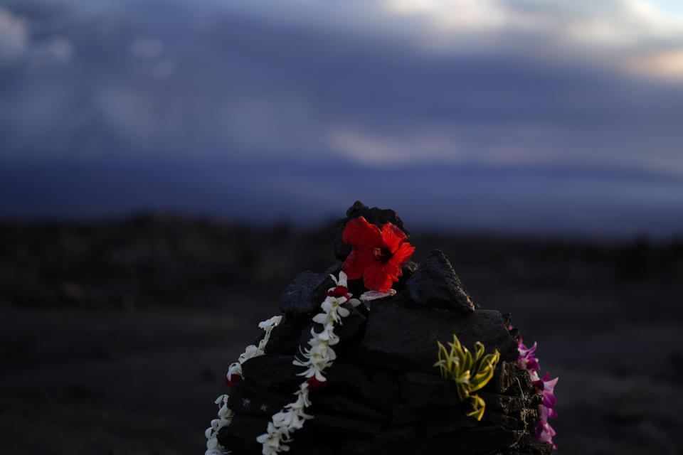 An offering sits among blackened lava rock from a previous eruption near the Mauna Loa volcano as it erupts Wednesday, Nov. 30, 2022, near Hilo, Hawaii. (AP Photo/Gregory Bull)