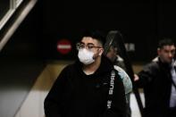 FILE PHOTO: A traveler wearing a mask arrives on a direct flight from China at Seattle-Tacoma International Airport