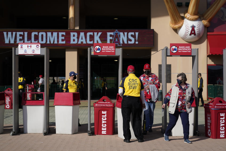 A security guard moves a barrier to allow fans to leave Angel Stadium when a baseball game between the Minnesota Twins and the Los Angeles Angels was postponed Saturday, April 17, 2021, in Anaheim, Calif. MLB said the game was postponed to allow for continued COVID-19 testing and contact tracing involving members of the Twins organization. (AP Photo/Ashley Landis)