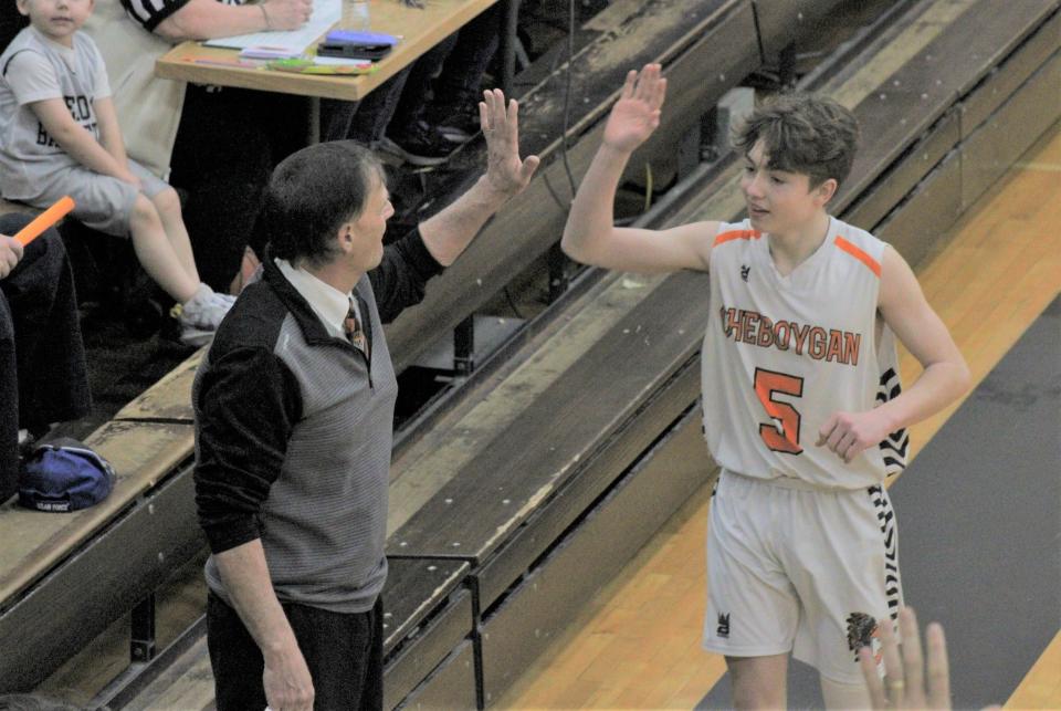 Cheboygan freshman Landon Gahn (5) celebrates with junior varsity boys basketball coach Scott Hancock following a victory for the Chiefs during the 2024 season. Gahn is one of many talented young players in the Cheboygan program.