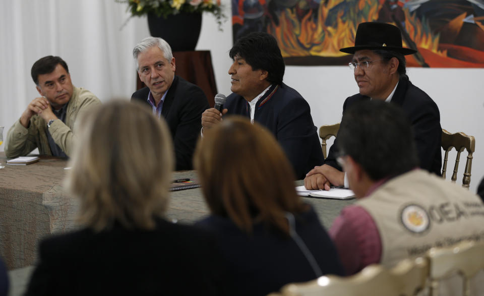 Bolivia's President Evo Morales, center, speaks at a meeting with Organization of American States delegates, flanked by Minister of the Presidency Ramon Quintana, from left, Vice President Alvaro Garcia Linera, and Foreign Minister Diego Pary, at the presidential palace in La Paz, Bolivia, Tuesday, Oct. 22, 2019. Rioting broke out in parts of Bolivia among opponents of Morales after electoral authorities announced that a resumed vote count after a day-long delay put the leader close to avoiding a runoff in his bid for a fourth term. (AP Photo/Juan Karita)