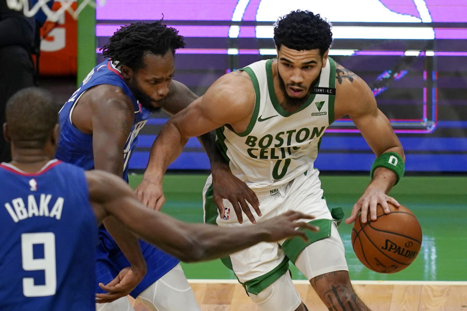 Boston Celtics forward Jayson Tatum (0) drives against Los Angeles Clippers guard Patrick Beverley, left, and center Serge Ibaka (9) in the third quarter of an NBA basketball game, Tuesday, March 2, 2021, in Boston. (AP Photo/Elise Amendola)