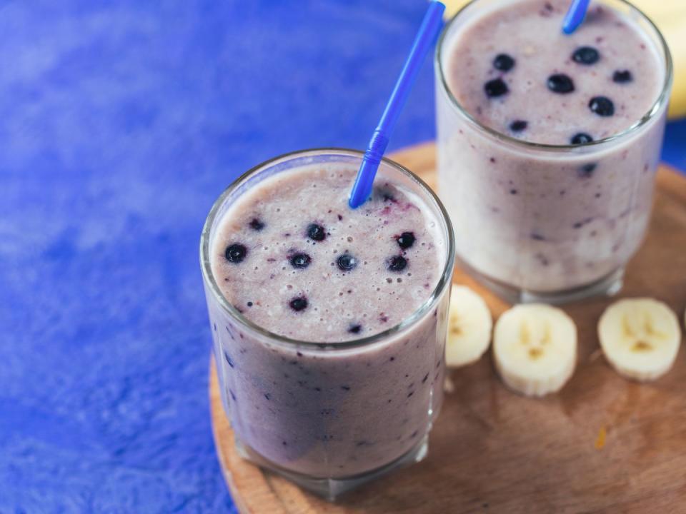 two glass glasses of blueberry smoothie with banana on the table