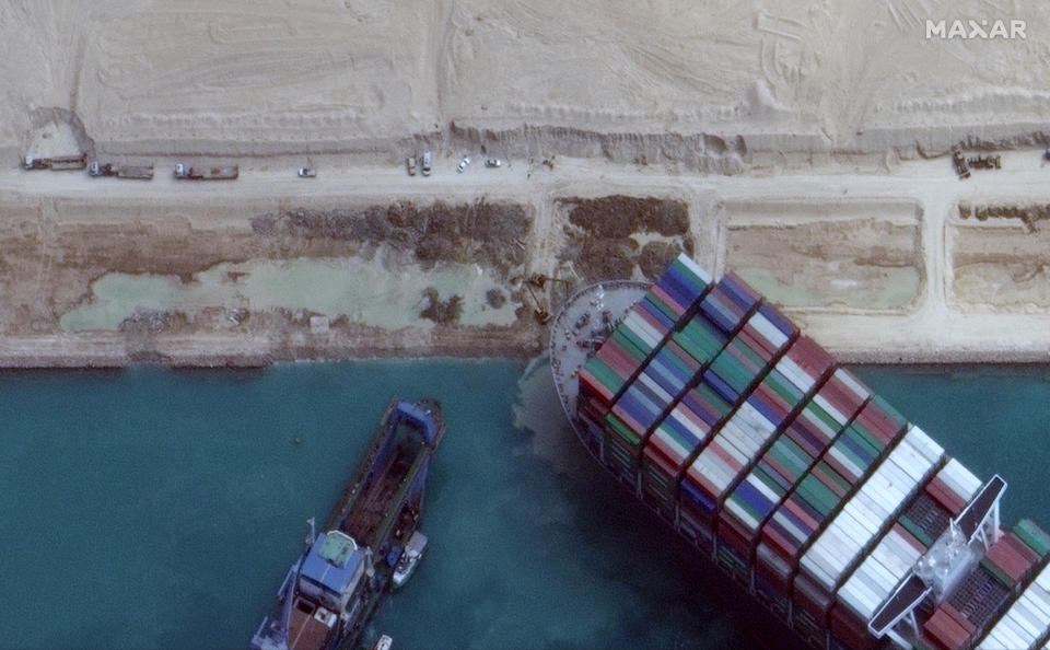 This satellite image from Maxar Technologies shows excavation work in an atempt to free the cargo ship MV Ever Given that is stuck in the Suez Canal near Suez, Egypt, Sunday, March 28, 2021. Two additional tugboats sped Sunday to Egypt's Suez Canal to aid efforts to free the skyscraper-sized container ship wedged for days across the crucial waterway, even as major shippers increasingly divert their boats out of fear the vessel may take even longer to free. (©Maxar Technologies via AP)