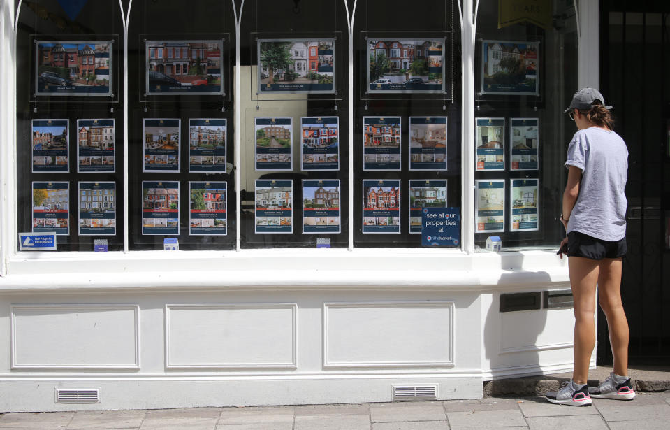 A woman studying the house price signs at an estate agents window in north London. Chancellor Rishi Sunak has confirmed temporary plans to abolish stamp duty on properties up to 500,000 GBP in England and Northern Ireland as part of a package to dull the economic impact of the coronavirus. Picture date: Sunday July 12, 2020.