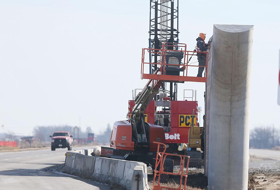 Constriction workers work on a new flyover bridge over HWY -30 between Ames and Nevada Monday, Feb. 19, 2024, near Ames, Iowa.