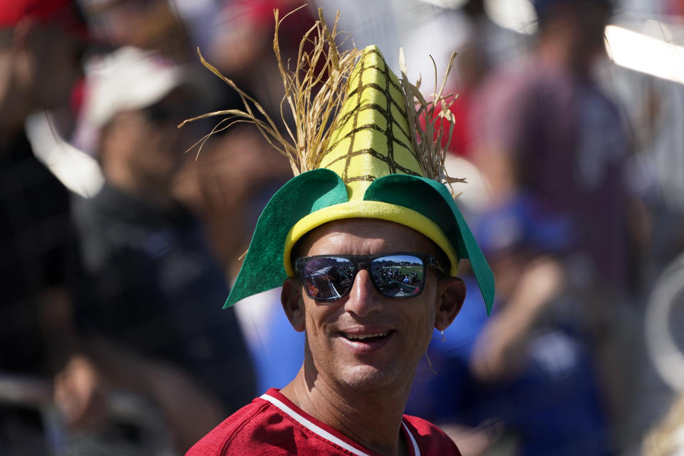 A fan watches the Cincinnati Reds take batting practice before a baseball game against the Chicago Cubs at the Field of Dreams movie site, Thursday, Aug. 11, 2022, in Dyersville, Iowa. (AP Photo/Charlie Neibergall)