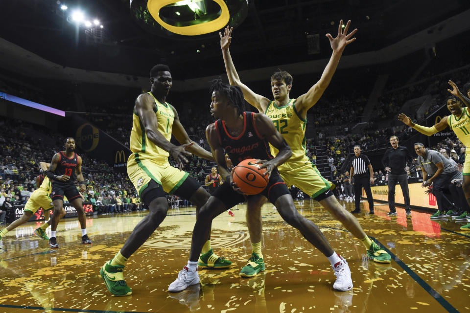Oregon centers N'Faly Dante (1) and Nate Bittle (32) pressure Houston guard Tramon Mark, center, during the first half of an NCAA college basketball game Sunday, Nov. 20, 2022, in Eugene, Ore. (AP Photo/Andy Nelson)