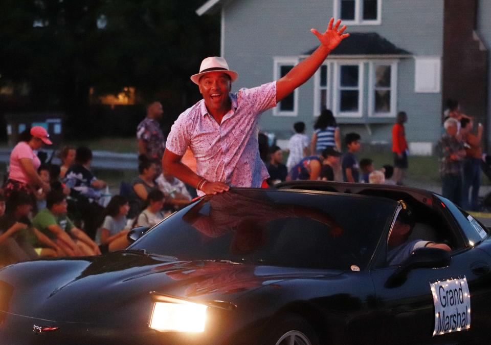 Mayor Jeff Mullins, serving as a grand marshal in Friday's electric parade, enthusiastically greets those in attendance.