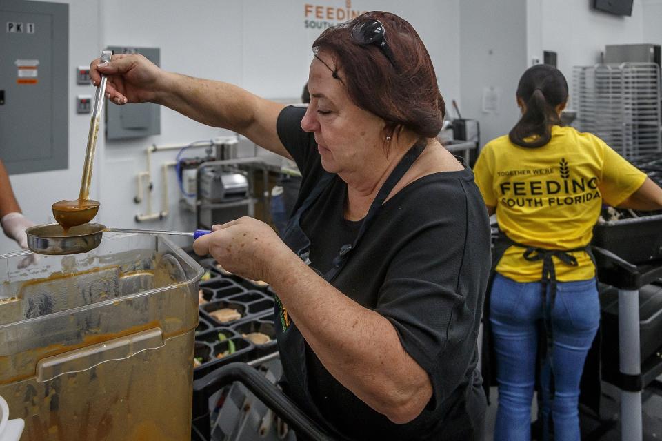 Kate Scrufari, Jupiter, left and Adriana Arevalo, Coral Springs, right prepared packaged meals at the Feeding South Florida operations center in Boynton Beach, Fla., on November 30, 2022.