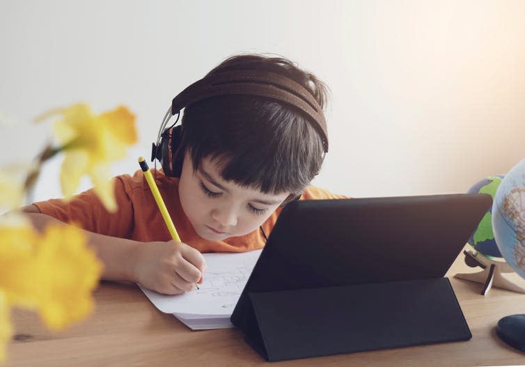 A child doing school work at home with a tablet